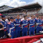 It wasn't to be F1 champion Jenson Button's 24 Hours, with his car suffering reliability gremlins; here he is lined up with his BR/SMP Racing team during the pre-race grid walk.